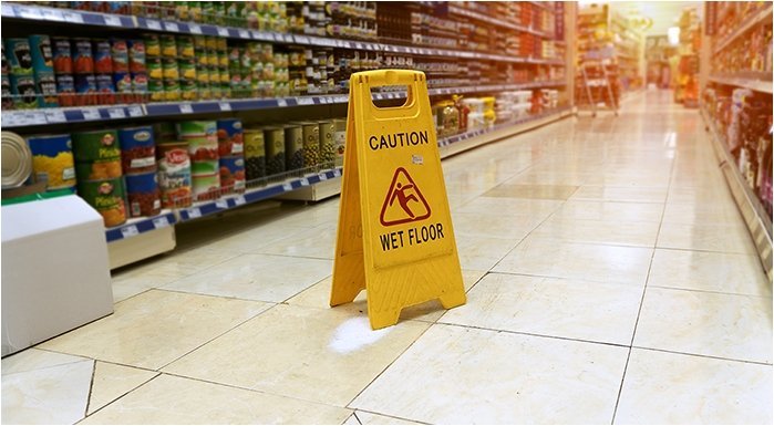 a 'caution - wet floor' sign in a grocery aisle